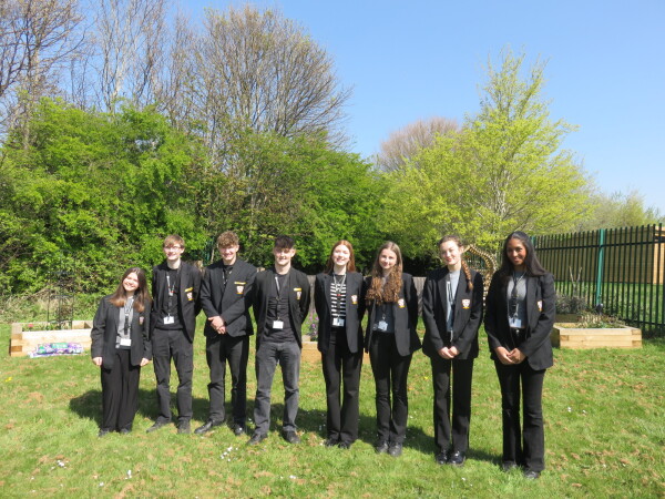 8 students standing outside in the sunshine 