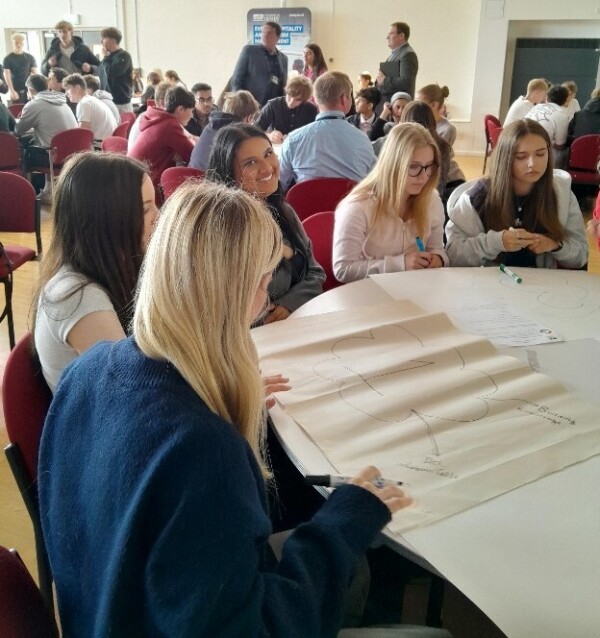 Students sitting around a table with flip chart paper