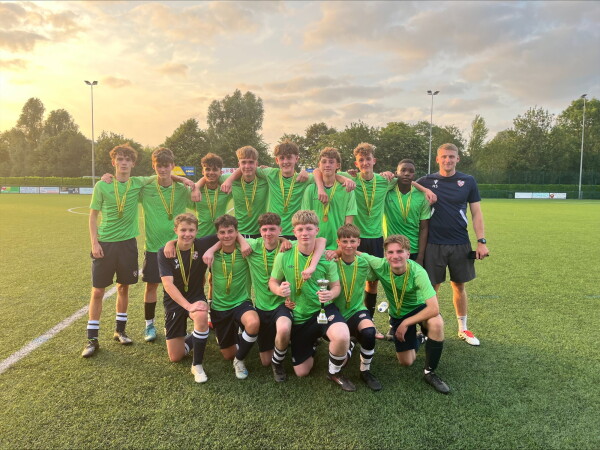 Year 10 football team in green kit on the pitch 